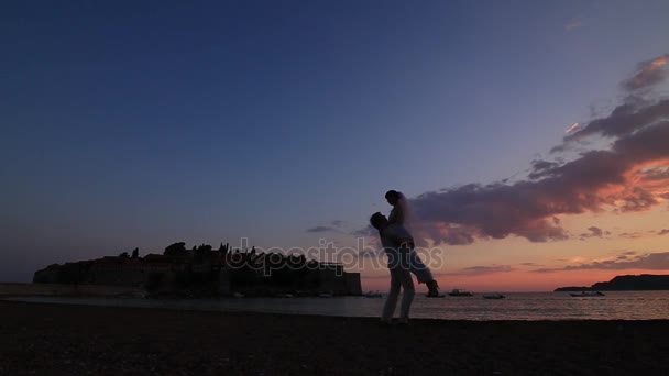 Silhueta de um casal recém-casado no mar ao pôr-do-sol. Casamento em — Vídeo de Stock