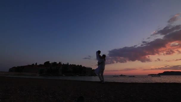 Silhueta de um casal recém-casado no mar ao pôr-do-sol. Casamento em — Vídeo de Stock