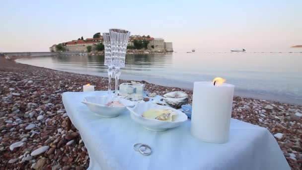 Cena a la luz de las velas en la playa. Una mesa para una d romántica — Vídeos de Stock