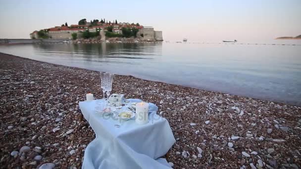 Cena a la luz de las velas en la playa. Una mesa para una d romántica — Vídeo de stock