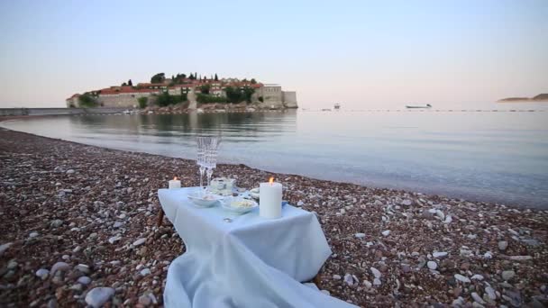 Cena a la luz de las velas en la playa. Una mesa para una d romántica — Vídeo de stock