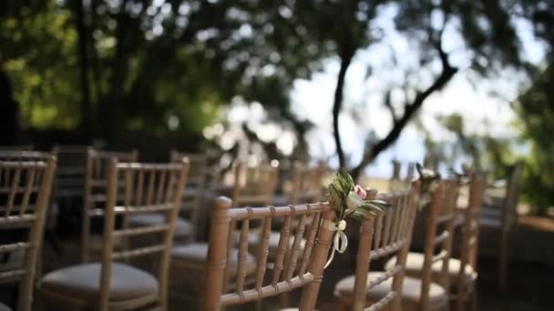 Sillas en una ceremonia de boda. Decorado con arreglos florales — Vídeos de Stock