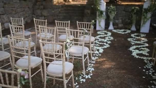 Sillas en una ceremonia de boda. Decorado con arreglos florales — Vídeos de Stock