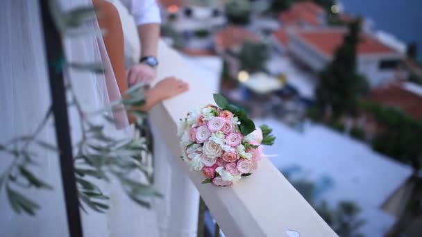 Весільний букет з рожевих троянд на кам'яному паркані з колонами — стокове відео