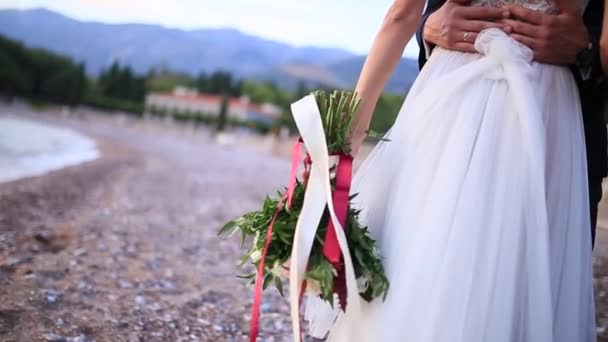 Ramo de bodas en manos de la novia en la playa Milocer Park — Vídeo de stock