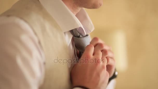 Человек завязывает галстук. Жених завязывает галстук. Доступ жениха к свадьбе — стоковое видео
