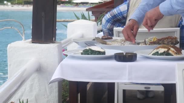 The waiter is cutting fish in the restaurant on table — Stock Video