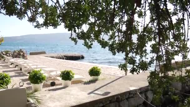 Witte kunststof ligbedden op het strand in Tivat — Stockvideo