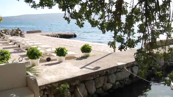 Camas de sol de plástico branco na praia em Tivat — Vídeo de Stock