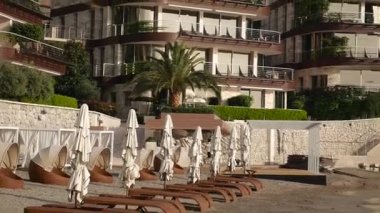 Şezlong ve şemsiyeleri sahilde. Karadağ plajları