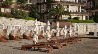 Şezlong ve şemsiyeleri sahilde. Karadağ plajları