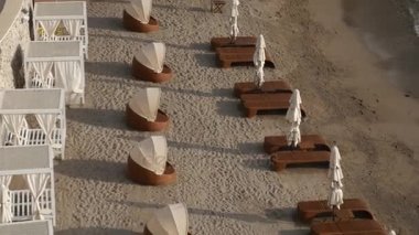 Şezlong ve şemsiyeleri sahilde. Karadağ plajları