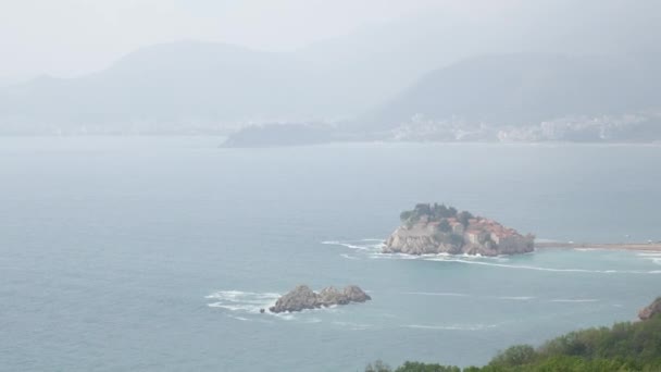 Isola di Sveti Stefan, vista dalla spiaggia di Crvena Glavica. Mont — Video Stock