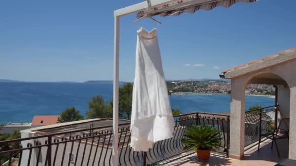 De bruid kleden fladdert in de wind op het balkon, tegen t — Stockvideo
