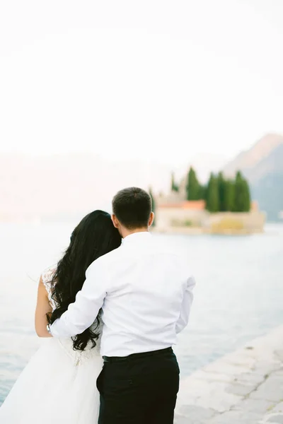 Жених обнимает невесту на пляже. Свадьба в Черногории — стоковое фото