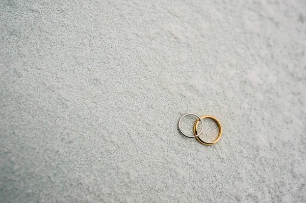 Anillos de bodas de recién casados en la nieve. Compromiso anillos de oro — Foto de Stock