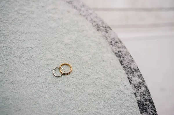 Anéis de casamento de recém-casados na neve. anéis de ouro noivado — Fotografia de Stock