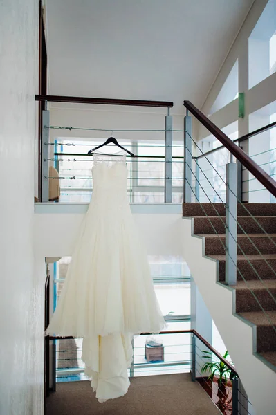 The brides dress on a hanger in the room