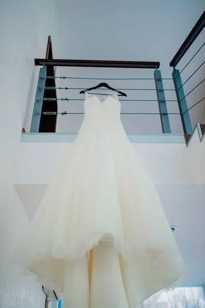 The brides dress on a hanger in the room