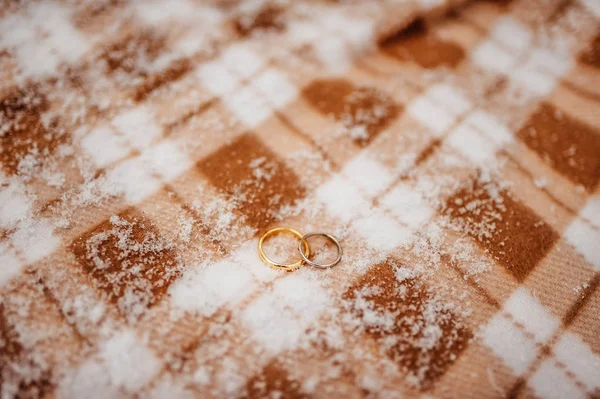 Snubní prsteny z novomanželů na sněhu. Zlaté zásnubní prsteny — Stock fotografie