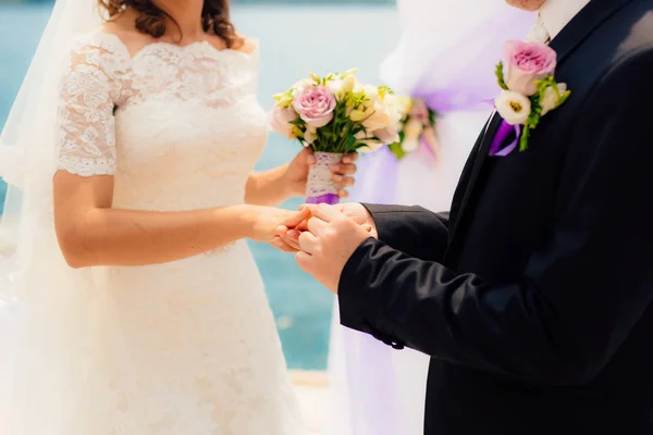 Les jeunes mariés échangent des alliances lors d'un mariage — Photo