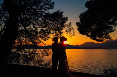 Sahilde gün batımında siluetleri