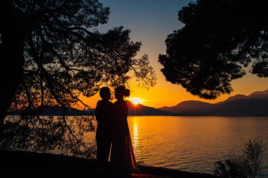 Sahilde gün batımında siluetleri