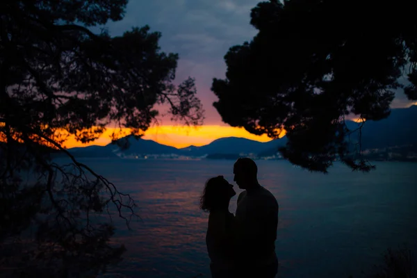 Silhouettes at sunset on the beach — Stock Photo, Image