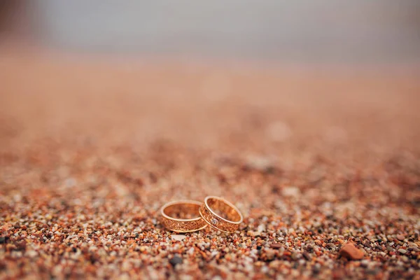 Anillos de boda de recién casados en guijarros de playa —  Fotos de Stock