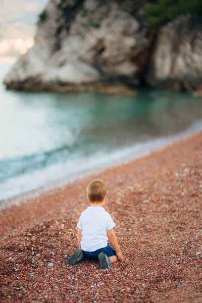 Seorang anak frustrasi menangis di pantai kerikil — Stok Foto