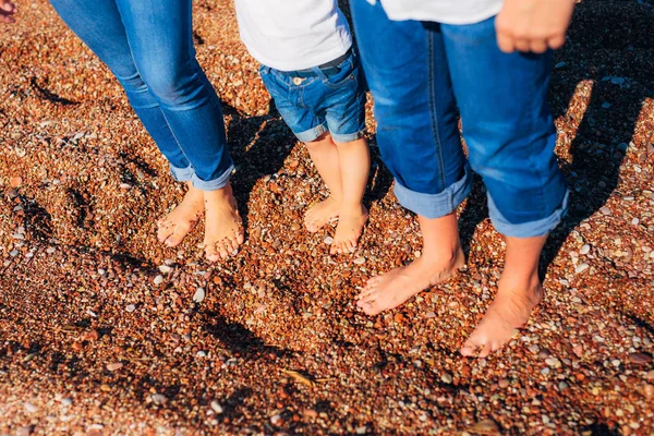 Niños piernas y pies de los padres. La familia camina por la playa —  Fotos de Stock