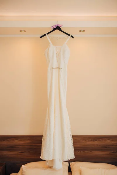 The brides dress on a hanger in the room