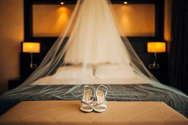 Zapatos de novia de plata en una cama antes de la ceremonia —  Fotos de Stock