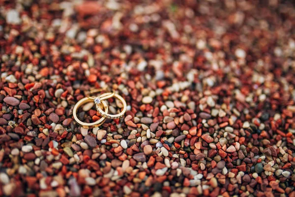 Wedding rings of newlyweds on beach pebbles — Stock Photo, Image