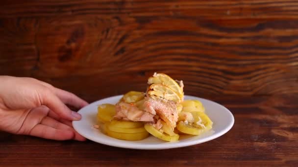 Salmón al horno con piña y rodajas de limón en un plato en un — Vídeo de stock