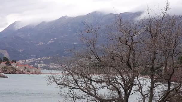 Isla Sveti Stefan, vista desde la playa de Crvena Glavica. Mont. — Vídeo de stock