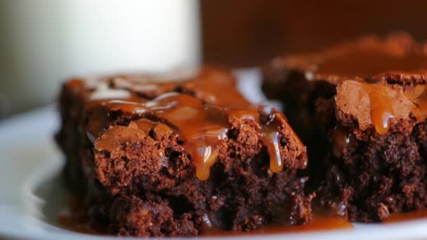 Brownie en un plato, en una textura de madera. Coche salado dulce regado — Vídeos de Stock