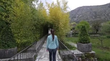 Kız bir bambu koru üzerinde yürür. İzleme çerçeve arkasında