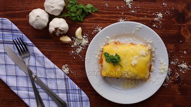 Rectangular Lasagna on a white plate. On a wooden background — Stock Video