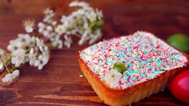 Pastel de Pascua en un plato, en una tabla de madera. Los huevos pintados en d — Vídeo de stock