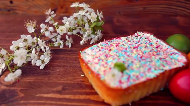 Easter cake on a plate, on a wooden board. The painted eggs in d — Stock Video