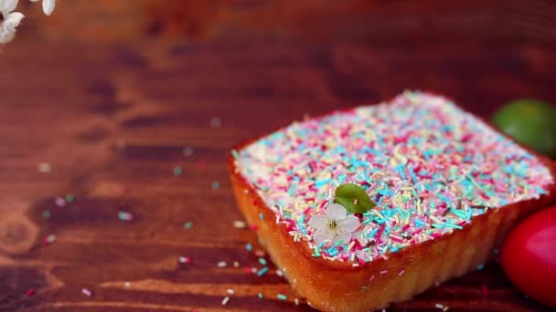 Osterkuchen auf einem Teller, auf einem Holzbrett. die bemalten Eier in d — Stockvideo