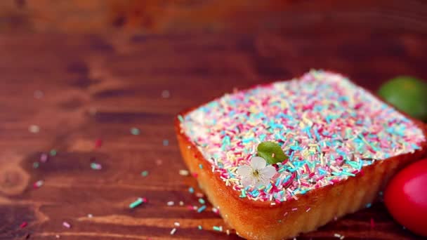 Osterkuchen auf einem Teller, auf einem Holzbrett. die bemalten Eier in d — Stockvideo