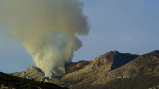 Ogień w górach w godzinach popołudniowych. Dym nad górami — Wideo stockowe
