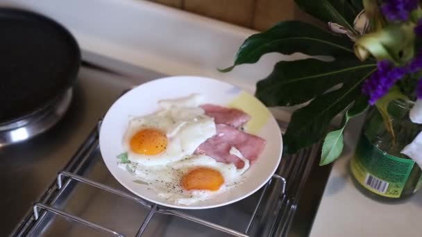 Huevos revueltos soleados boca arriba en un plato con salchicha. La chica... — Vídeo de stock