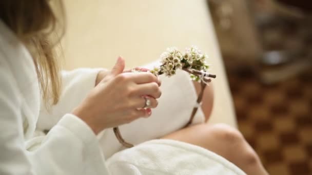 La mariée dans une robe d'hôtel blanche tisser couronne gypsophila — Video