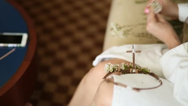 La novia en un vestido de hotel blanco tejió guirnalda gypsophila — Vídeo de stock