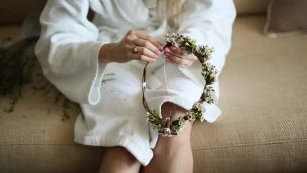 Bruden i en vit hotel klänning vävde krans gypsophila — Stockvideo