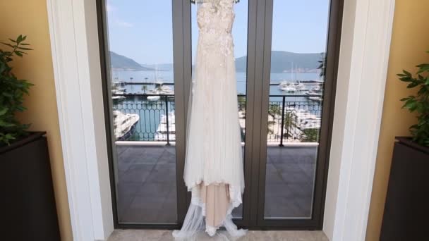Brudklänning brudar klänning hänger i fönstret, i vilken th — Stockvideo