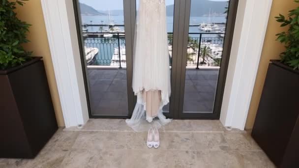 Brudklänning brudar klänning hänger i fönstret, i vilken th — Stockvideo